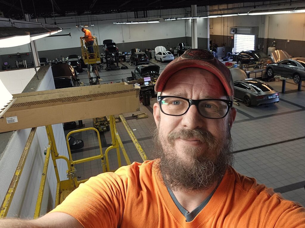 Image of Dustin Rinker on a lift installing energy efficiency lighting.