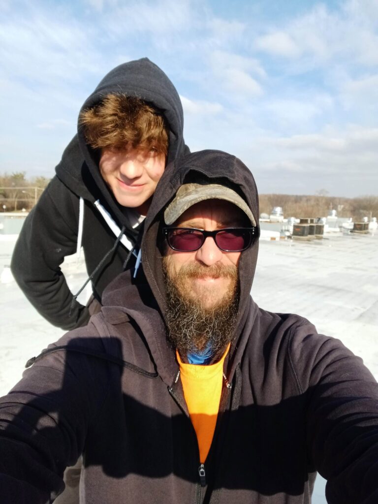 Image of Logan & Dustin Rinker on a roof changing lights.